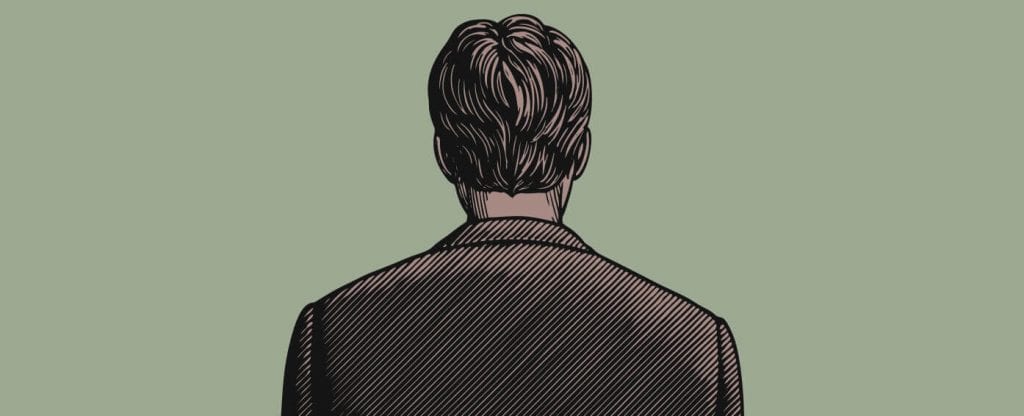 The back of a man standing in a suit jacket